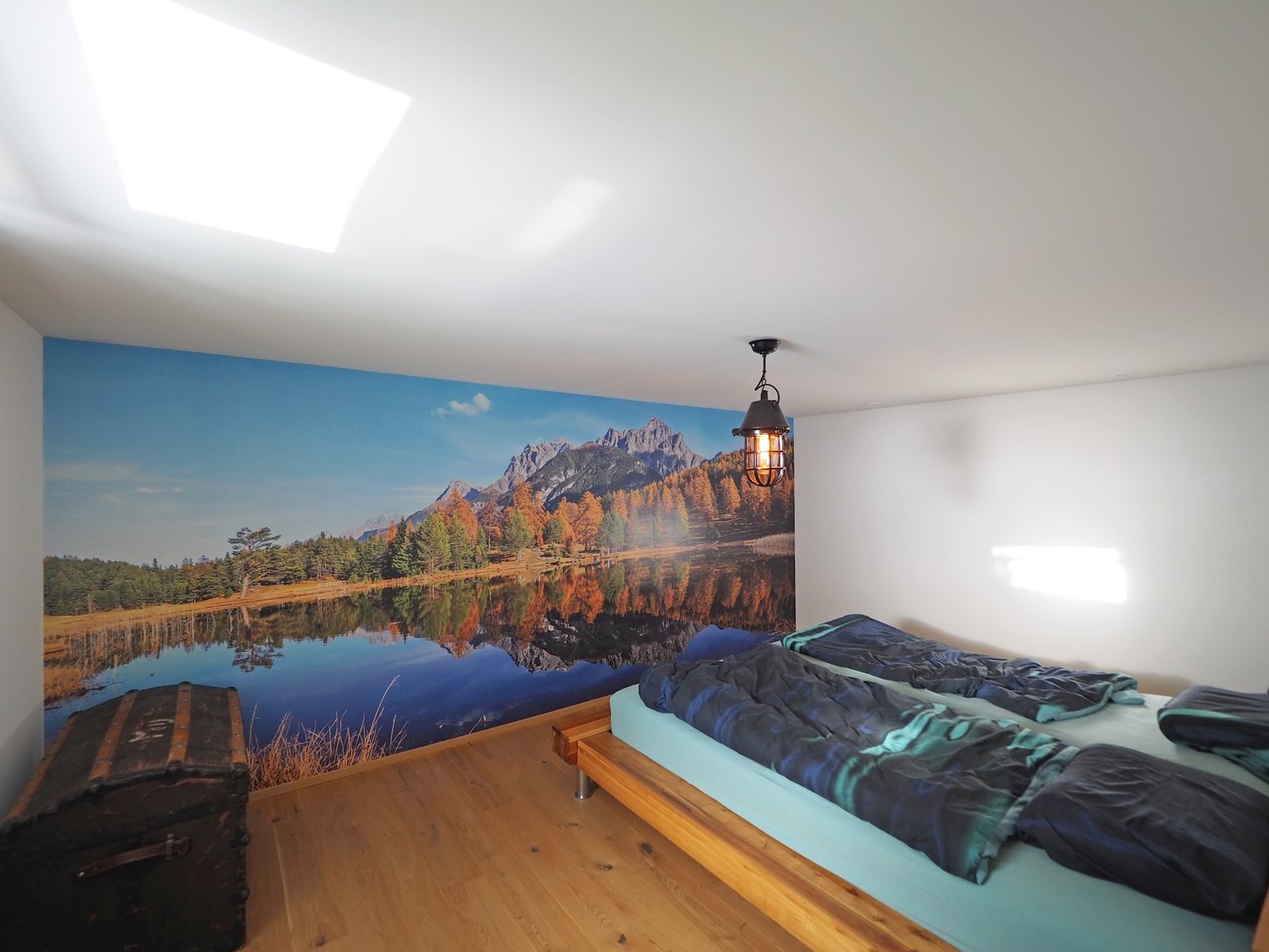 Schlafzimmer mit Berg-See-Wandbild über die ganze Wand